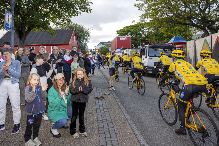 a group of people standing next to a road with bikes