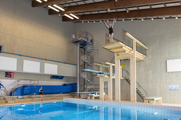 a person standing on a staircase above a swimming pool
